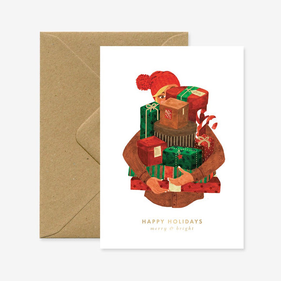 A Christmas greeting card with a illustration of Santa Claus and gifts, with a brown envelope.