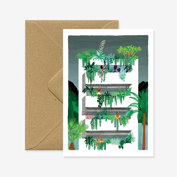 A greeting card with a floral and botanical illustration, featuring gold foil details, accompanied by a recycled brown envelope.