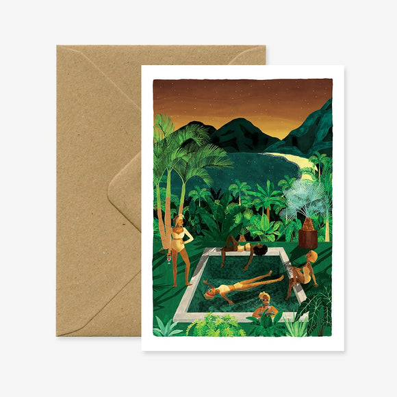 A greeting card with an illustration of a person relaxing by a pool surrounded by tropical plants. The card is accompanied by a brown envelope.