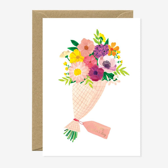 A greeting card featuring a colorful illustration of a bouquet of flowers with gold foil details, accompanied by a brown envelope.