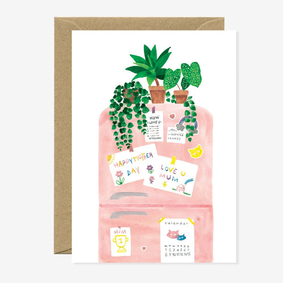 A greeting card with an illustration of a refrigerator with notes and plants on it, accompanied by a brown envelope.