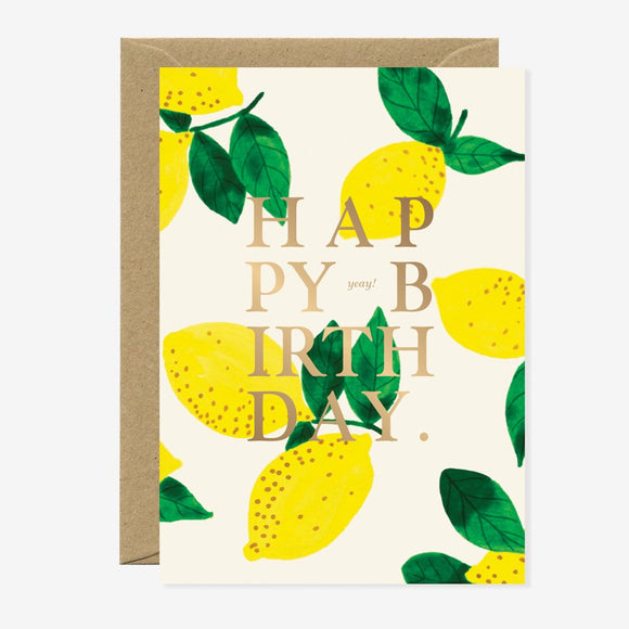 A birthday greeting card with a lemon pattern and the text 'HAPPY BIRTHDAY' on the front, accompanied by a brown envelope.