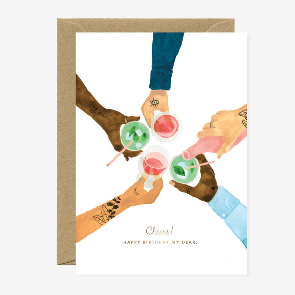 A birthday greeting card with a illustration of multiple hands toasting with colorful drinks, accompanied by text 'Cheers! Happy Birthday to You.' The card is accompanied by a brown envelope.