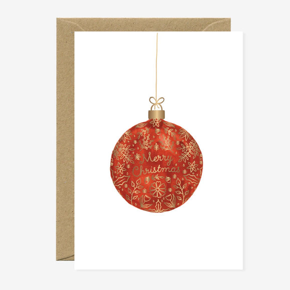 A Christmas greeting card featuring a red and gold ornate bauble with the text 'Merry Christmas' on it, accompanied by a brown envelope.