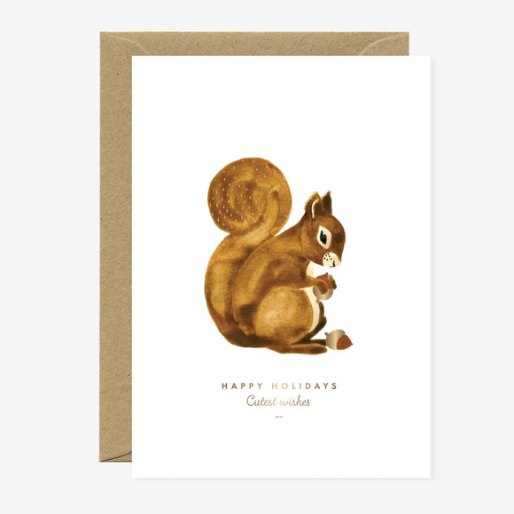 A Christmas greeting card featuring a gold foil detailed illustration of a squirrel on a natural white background with the text 'Happy Holidays' and a brown envelope.