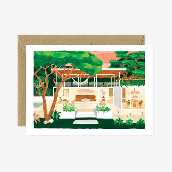 A greeting card with a illustration of a house and trees, accompanied by a brown envelope.