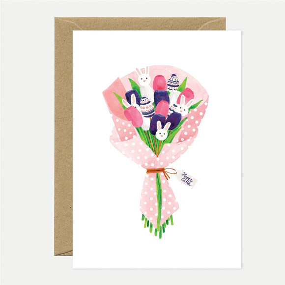 A greeting card depicting a bouquet with cartoon-style rabbits and eggs, tied with a ribbon, accompanied by a recycled brown envelope.