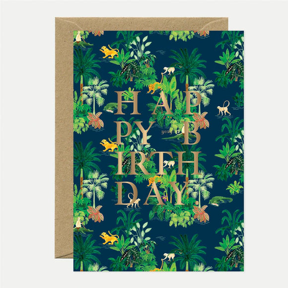 A birthday greeting card with a gold foil pattern and green botanical print, featuring the text 'HAPPY BIRTHDAY' in bold letters.