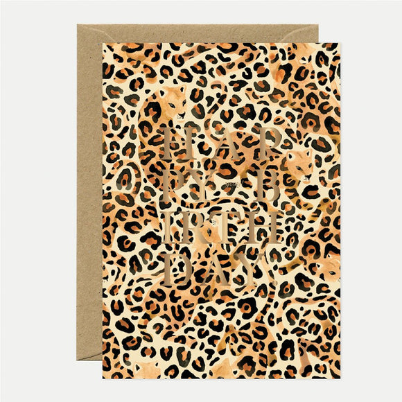 A birthday greeting card with a leopard animal print and gold foil details, accompanied by a recycled brown envelope.