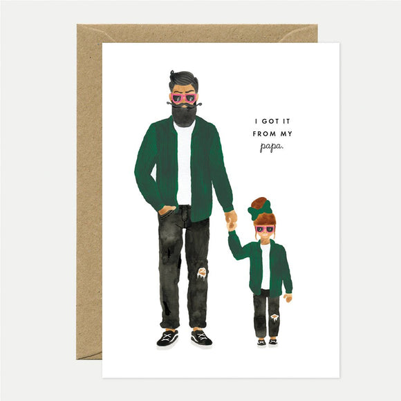 Illustrated greeting card depicting a father and daughter wearing green cardigans, with the text 'I GOT IT FROM MY PAPA' on the card. A brown envelope is included.