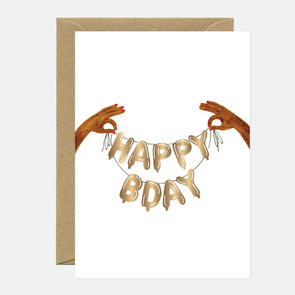 A birthday greeting card with gold foil details showing two hands holding a banner that reads 'HAPPY BDAY'. The card is accompanied by a brown envelope.