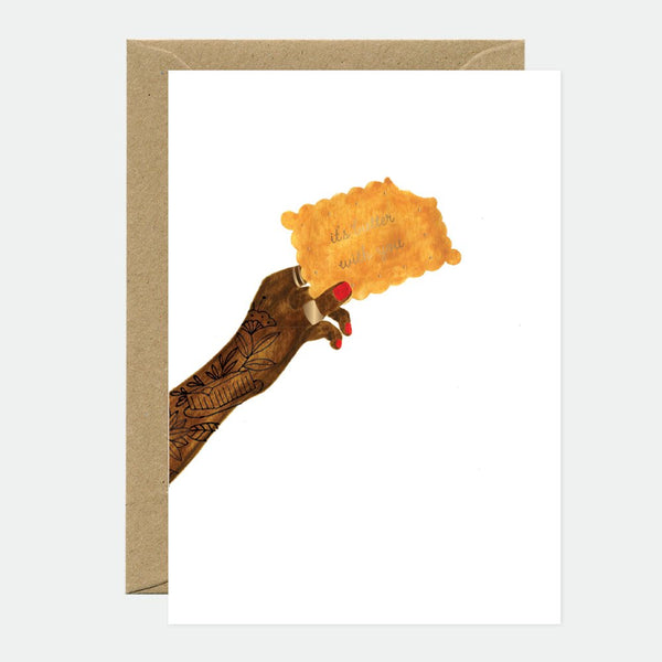 A greeting card with a gold foil detailed illustration of a hand holding a piece of butter, with a natural white envelope.