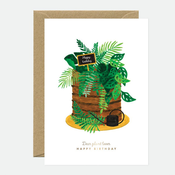 A birthday greeting card with a gold foil detailed illustration of a plant pot and leaves, titled 'Jungle day - Birthday Greeting card - Gold foil'. The card is accompanied by a recycled brown envelope.