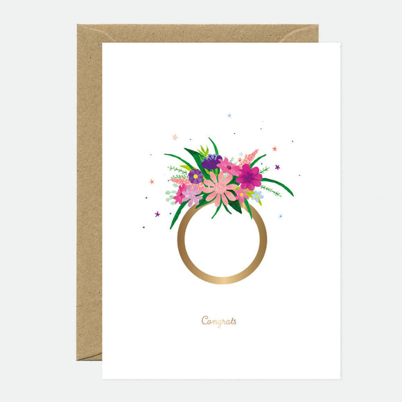 A white greeting card with a floral design and a gold foil circle, accompanied by a brown envelope. The word 'Congrats' is printed on the card.
