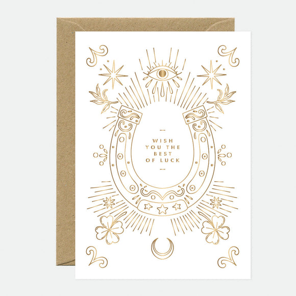 A white greeting card with gold foil horseshoe design and the text 'WISH YOU THE BEST OF LUCK', accompanied by a brown envelope.