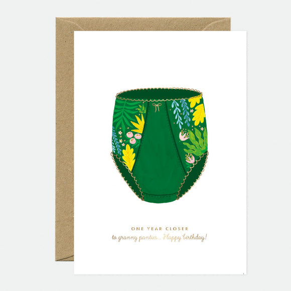 This image features a whimsical A6 greeting card titled "Granny Panties - Birthday Greeting card - Gold foil," which is printed in France. The card displays a unique and playful illustration of a green garden hose adorned with various plants and flowers, giving it a vibrant and cheerful look.