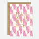 A greeting card with multiple pink cat illustrations and the words 'HAPPY BIRTHDAY' in gold foil.