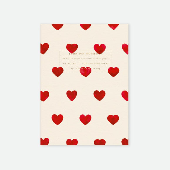 A5 notebook with gold foil cover featuring a pattern of red hearts
