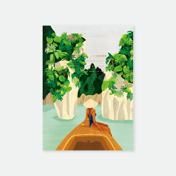 Bay Notebook A5 – illustrated cover with boat, tropical cliffs, lush greenery, and contemplative figure, gold foil details, by All the Ways to Say.