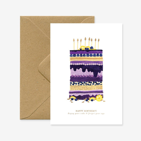 A birthday greeting card with a blueberry cake illustration on it, accompanied by a brown envelope.