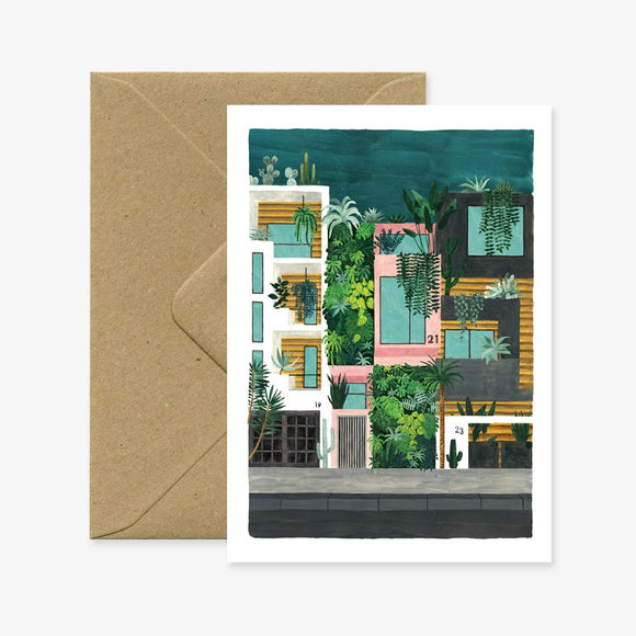 A greeting card with an illustration of a building featuring a lot of plants, accompanied by a brown envelope.
