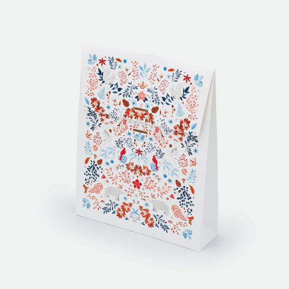 White Winter Gift Bag by All the Ways to Say featuring snowy white background with red, blue and orange floral and animal motifs, available in two sizes.