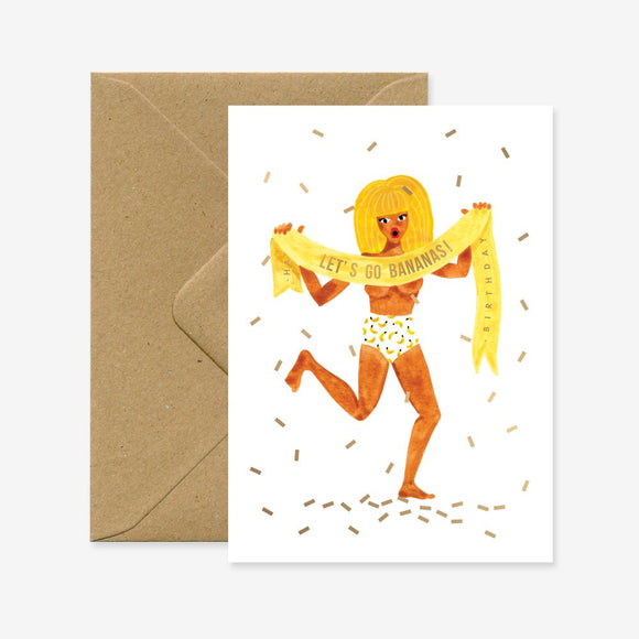 A birthday greeting card with an illustration of a person covered in bananas, holding a banner that says 'BANANAS!!!', with gold foil details and a brown envelope.