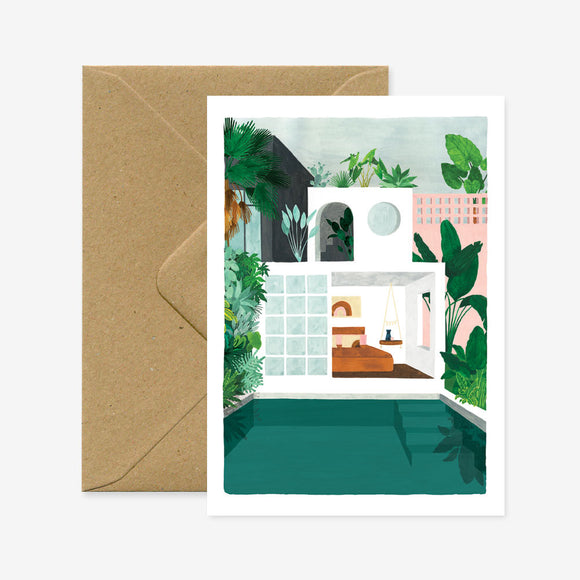 A greeting card depicting a colorful illustration of a house with a pool and plants, accompanied by a brown envelope.