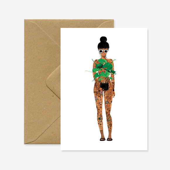 Greeting card with an illustration of a woman holding a plant, wearing a patterned outfit, accompanied by a brown envelope