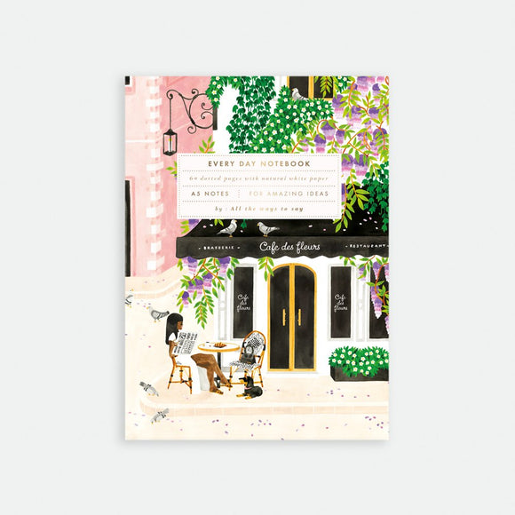 A floral-patterned notebook with an illustration of a cafe on the cover, titled 'Every Day Notebook'.