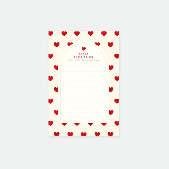 A notepad with a white background and a border of red hearts. The notepad has text at the top which seems to be a brand or product name.