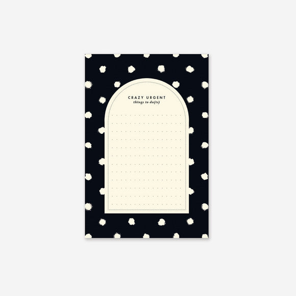 A notepad with a black cover featuring vibrant painted dots and a Cream colored paper inside.