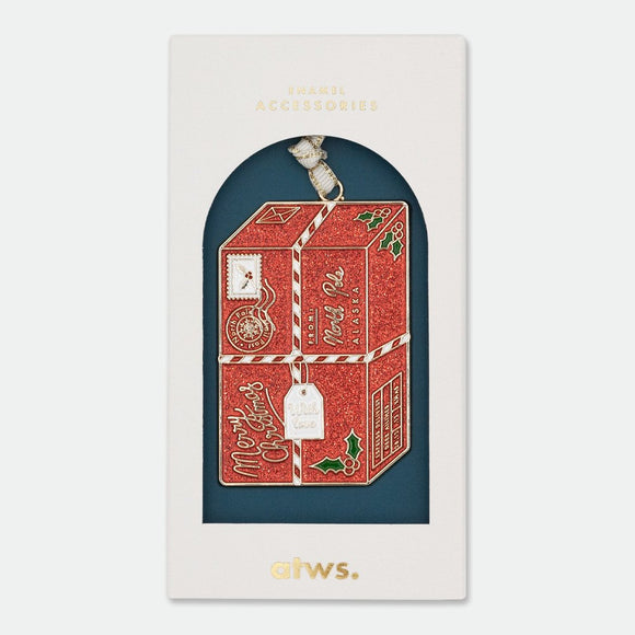 Santa’s Package Christmas Ornament – enamel decoration shaped like a glittering red North Pole parcel with gold plating, by All the Ways to Say.