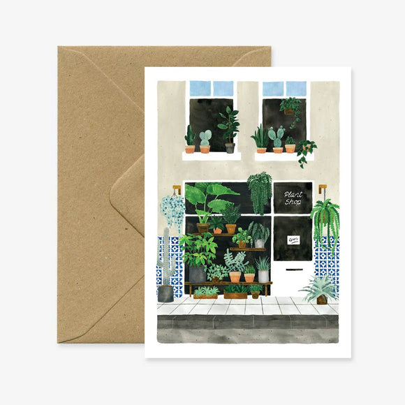 A greeting card with an illustration of various potted plants displayed in a window sill, accompanied by a recycled brown envelope.