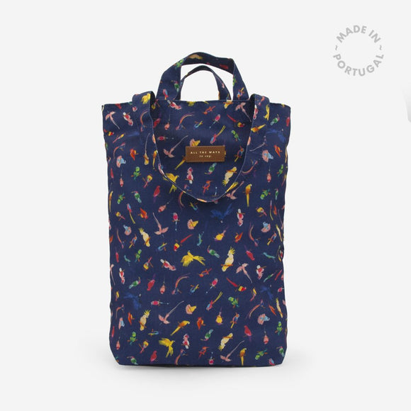 Neon Birds Tote Bag by All the Ways to Say in recycled polyester with colorful parrot pattern, navy background, and gold embossed vegan leather tag