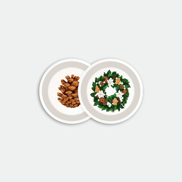 Round coaster tray with pinecone and holiday wreath illustrations on white background, made of birch wood