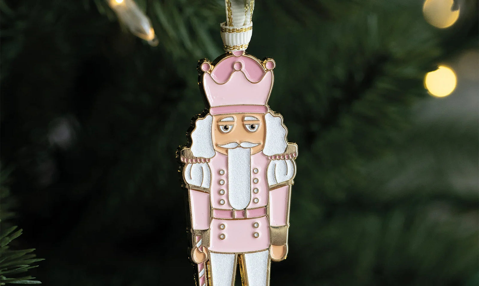 All the Ways to Say Christmas ornaments – pink nutcracker enamel decoration hanging on a tree