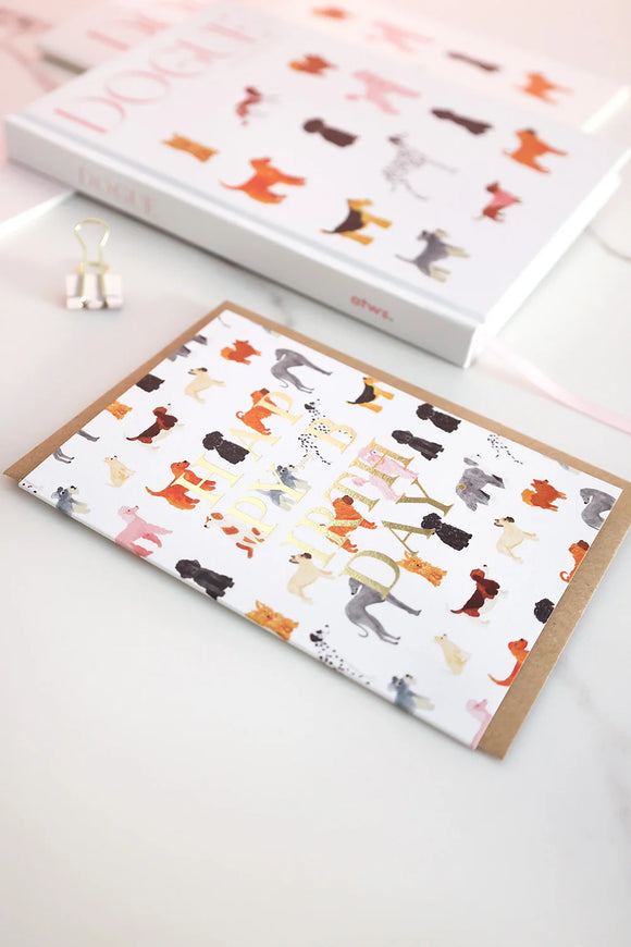Birthday card with multicolored dog pattern and gold foil “Happy Birthday” text, styled with matching Dogue notebooks.