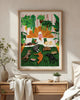 A bright bedroom interior mockup featuring the "Life with plants & pets" art print in a natural light wood frame hanging on a beige textured wall. The hand-painted illustration portrays a relaxing scene of a woman in a white bathrobe reading a book in bed, surrounded by lush hanging indoor plants and seven sleeping dogs and cats on a green striped blanket. Below the poster sits a light wooden dresser decorated with a ceramic bowl, a soft beige throw blanket, and a small potted green plant under warm sunligh