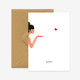 A greeting card with a illustration of a person blowing a kiss, accompanied by the word 'bisou' on the bottom, presented with a brown envelope.