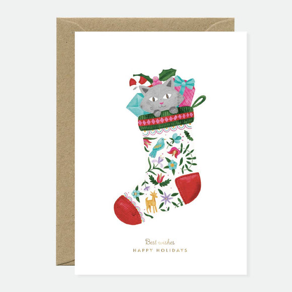 Greeting card with an illustration of a cat wearing a Christmas stocking, decorated with holiday-themed patterns and a red bow, paired with a brown envelope.