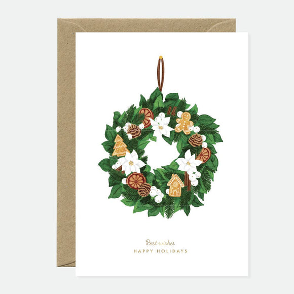 Greeting card with an elegant Christmas wreath decorated with pinecones, gingerbread cookies, dried oranges, and white flowers, with gold foil accents.