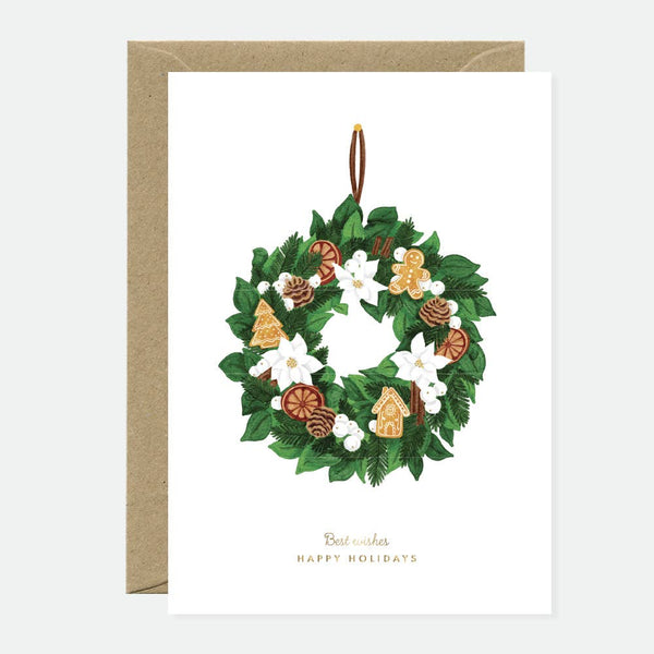 Greeting card with an elegant Christmas wreath decorated with pinecones, gingerbread cookies, dried oranges, and white flowers, with gold foil accents.