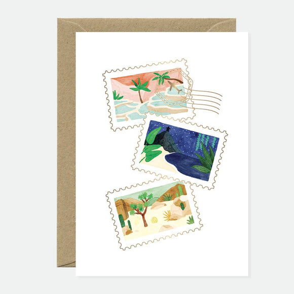 A greeting card with a series of gold foil stamps depicting various travel scenes such as a beach, a forest, and a cityscape.