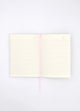 Open Dogue notebook showing lined cream pages with pink ribbon bookmark for writing and journaling.