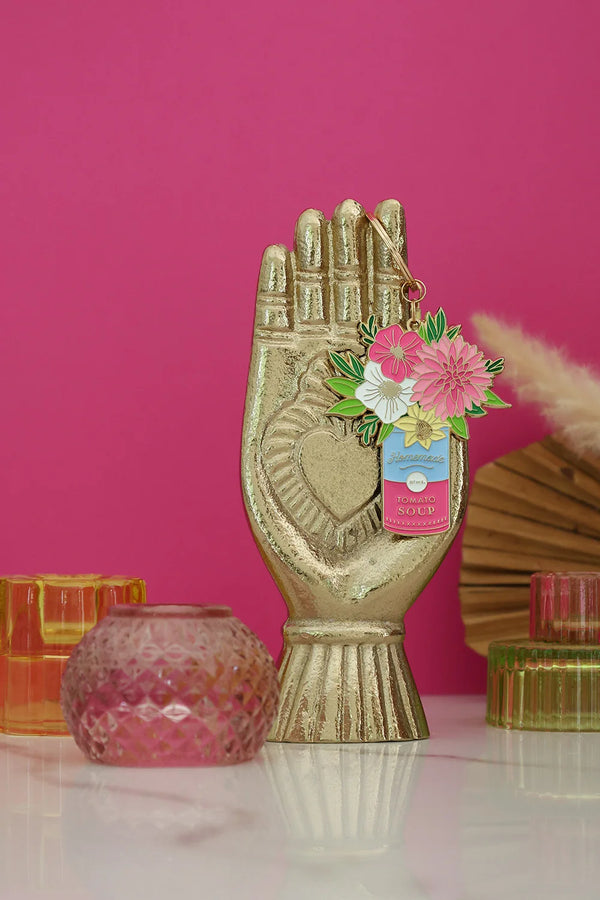 Flower Can keychain by All The Ways To Say displayed on golden hand statue with pink background