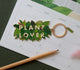All The Ways To Say Plant Lover enamel keychain – lush green jungle leaves with gold details