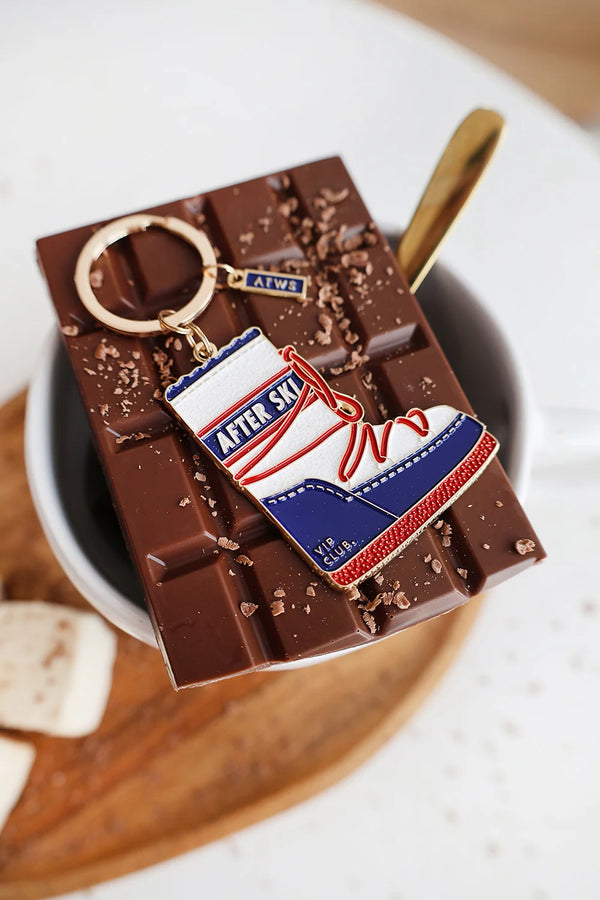 After Ski keychain by All The Ways To Say – enamel boot charm on melted chocolate background