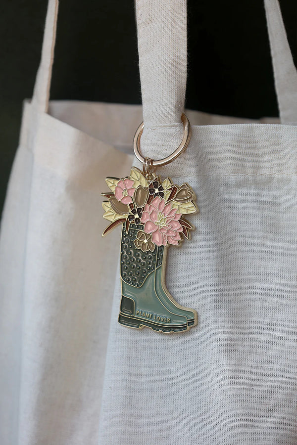 Plant Lover Boots keychain by All The Ways To Say hanging on canvas tote bag – floral enamel boot design