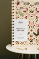 Front cover of Pink Croco monthly planner with white label and gold spiral binding